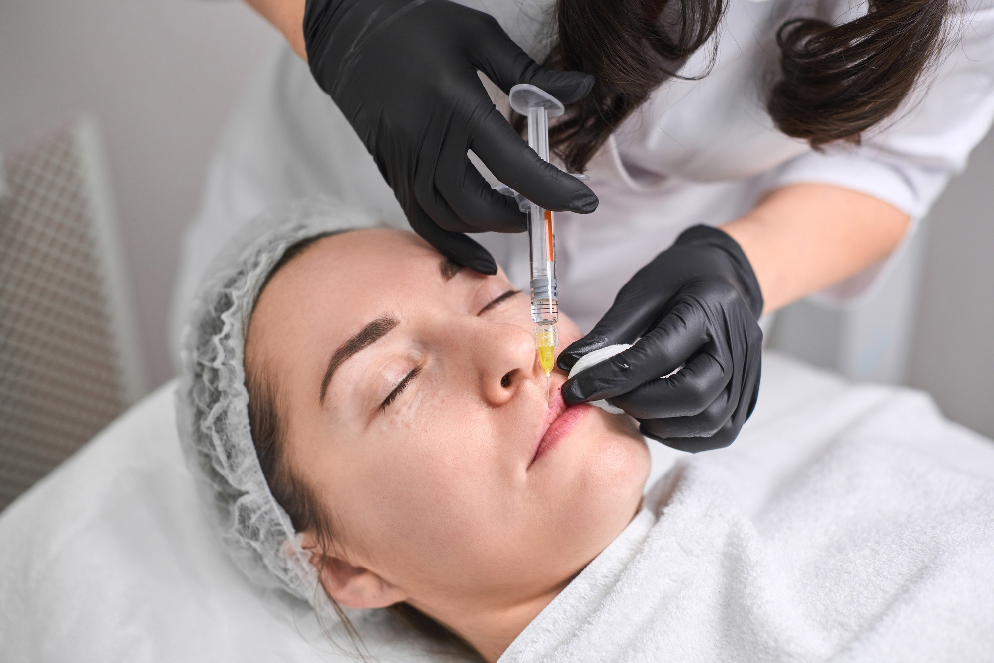 young woman undergoing non surgical cosmetic procedure in clinic
